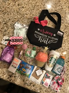 the contents of a starbucks bag laid out on top of a granite countertop in front of a black tote bag