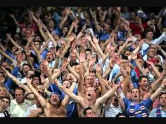 a large group of people with their hands up in the air at a sporting event