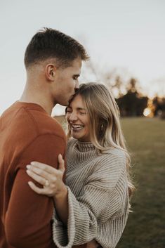 a man and woman embracing each other in an open field