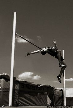 a man is in the air on a pole