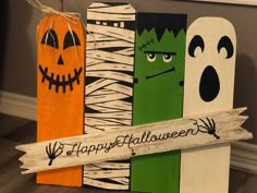 halloween decorations made out of wood sticks and painted to look like ghostes, pumpkins, and bats