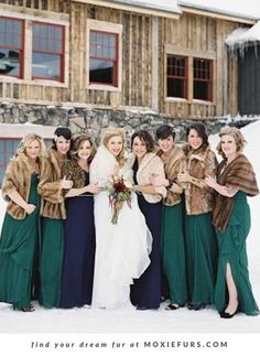 a group of women standing next to each other in front of a snow covered building