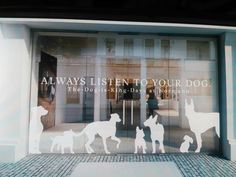 an advertisement on the side of a building with dogs and people walking in front of it