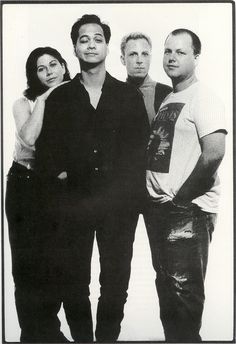 four people are posing for a black and white photo