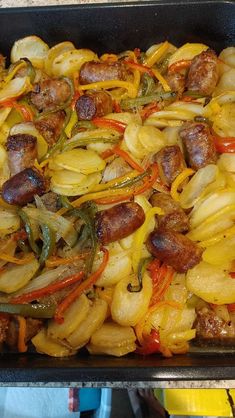 a pan filled with sausage, onions and peppers