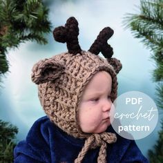 a baby wearing a knitted hat with antlers on it