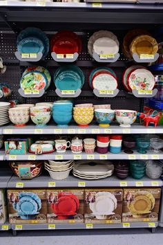 the shelves are filled with colorful dishes and plates on display for sale in a store