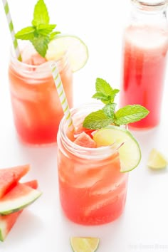 two mason jars filled with watermelon lemonade and mint garnishes