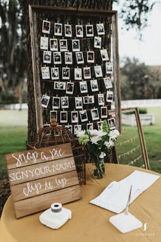 a wooden sign sitting on top of a table next to a vase filled with flowers