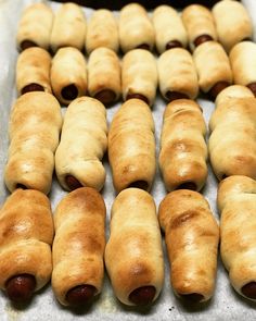 hotdogs wrapped in bread are lined up on a baking sheet and ready to be baked