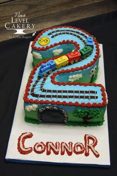 a birthday cake that is shaped like a train track and has the number two on it