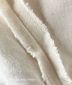 closeup of white fabric with holes in the middle and frayed edges on it