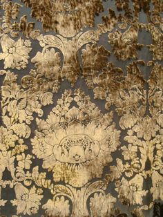 an old wallpaper with brown and white designs on the surface, including leaves and flowers