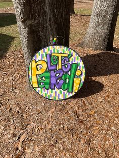 a sign that is on the ground next to a tree and some leaves in front of it