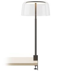 a lamp that is sitting on top of a table with a white shade over it