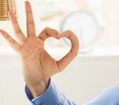 a person making a heart shape with their hand