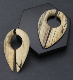 two pieces of wood sitting next to each other on a black surface with hexagonal shapes