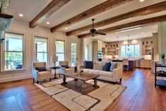 a living room filled with furniture and lots of windows next to a wooden flooring