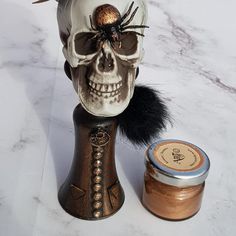 a skull with a hat on top of it next to a jar