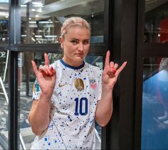 a woman is making the peace sign in front of a glass door with her hands