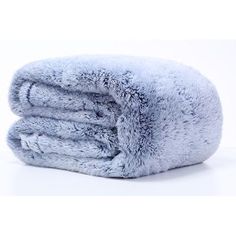 a pile of fluffy blue blankets sitting on top of each other in front of a white background