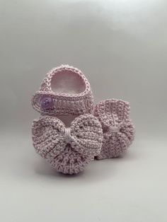 a pair of crocheted baby shoes with a bow on the front and bottom