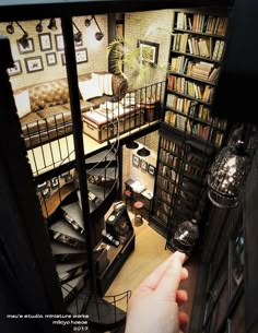 a person is pointing at the bookshelves in a room that has many shelves full of books