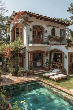 a house with a pool in front of it and lots of plants on the outside