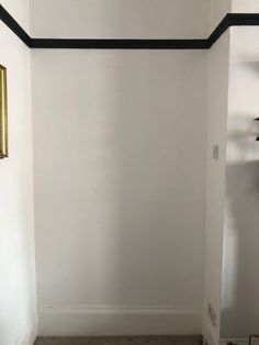 an empty room with white walls and black trim