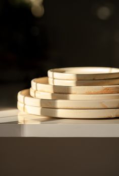 a stack of wooden plates sitting on top of a table