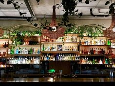 a bar with lots of bottles and lights hanging from the ceiling