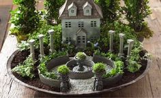 a miniature house in the middle of a garden