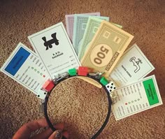 a person is holding some money in front of their headband on the carpeted floor