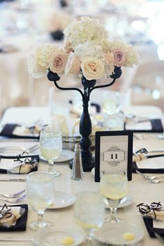 there is a table set up with white flowers and place settings for the guests to eat