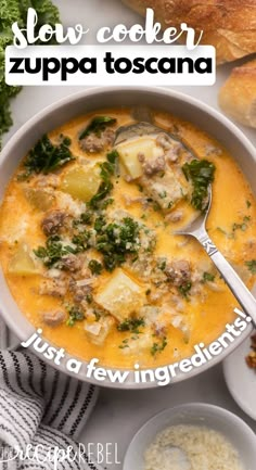 a white bowl filled with soup next to bread and other food on a table top