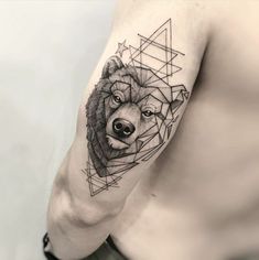 a man's arm with a bear tattoo on it and geometric shapes around him