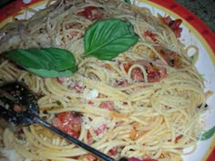 a plate of spaghetti with basil leaves on top