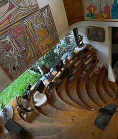 an aerial view of the inside of a building with wooden stairs and paintings on the walls