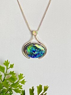 "❤Vibrant Dichroic Glass Pendant in a silver plated setting. This dichroic pendant is 34.6 mm X 30 mm (1.36 in  x .1.2 in).  The dichroic glass is set in a nickel free silver plated bezel with a 5 mm peridot Swarovski crystal at the top.   ❤It has been made with multiple layers of dichroic glass, hand shaped with a diamond saw, glass grinder and then fired multiple times in the kiln.  The pendant has a base layer of black and has vibrant dichroic colors of green, pink, blue and gold dichroic shimmers.  My glass designs are created with a passion for color, texture, and the dimensional dynamics that only multiple layers of glass create.   ❤Dichroic glass is produced by stacking layers of glass and micro layers of Quartz Crystal and Metal Oxides (which are vaporized in a vacuum chamber and t Iridescent Glass Jewelry Gift, Dichroic Pendant, Colors Of Green, Dichroic Glass Pendant, Glass Designs, Hand Shapes, Dichroic Glass, Gift For Friend, Glass Decor