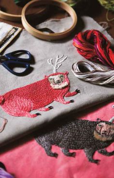 the table is covered with various crafting items and thread spools on it