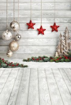 an image of christmas decorations hanging on the wall in front of a wooden background with red stars