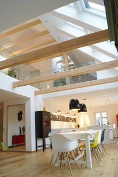 an open floor plan with white furniture and wooden beams on the ceiling is very modern