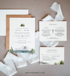 the wedding stationery is laid out on top of torn paper