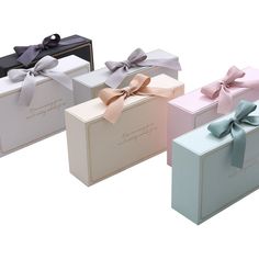 three different colored boxes with bows on them