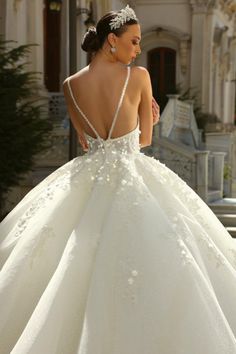 the back of a wedding dress with flowers on it is shown in front of a building