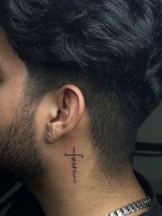 a man with a cross tattoo on his neck and behind the ear is a chain