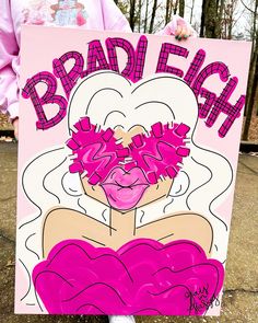 a person holding up a sign that says brad each with flowers in her hair