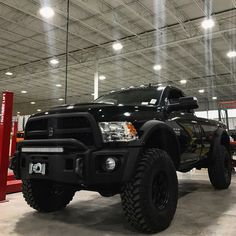 a large black truck parked in a garage