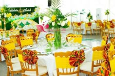 tables and chairs are set up for an event with flowers in vases on them