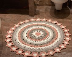 a crocheted round rug on the floor in a bathroom